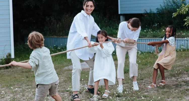 Family playing tug of war in backyard, showcasing teamwork and joy.